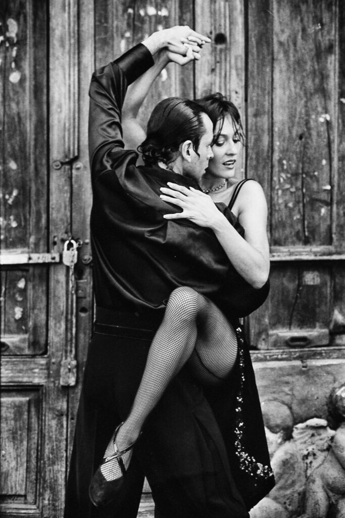 Dramatic black and white portrait of a couple passionately dancing tango.